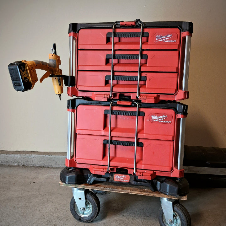 Two Milwaukee Tool Boxes stacked on top of each other with a glue gun hanging in a mounted arm.