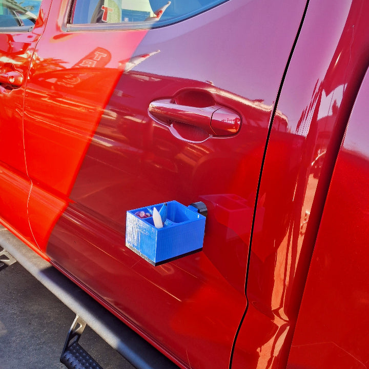 An organizer for glue pulling in paintless dent repair with magnets stuck to the side of a truck door panel