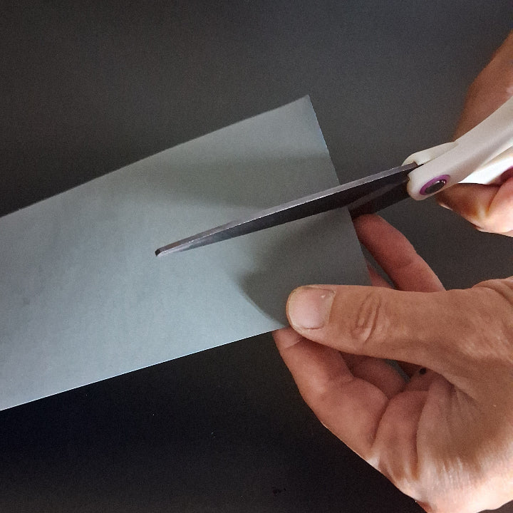 Cutting sandpaper to size so that it fits in a sanding block