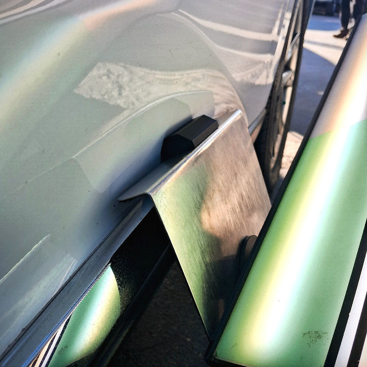 A window guard being used to mount a Paintless Dent Repair light so that a dent can be removed from a car door