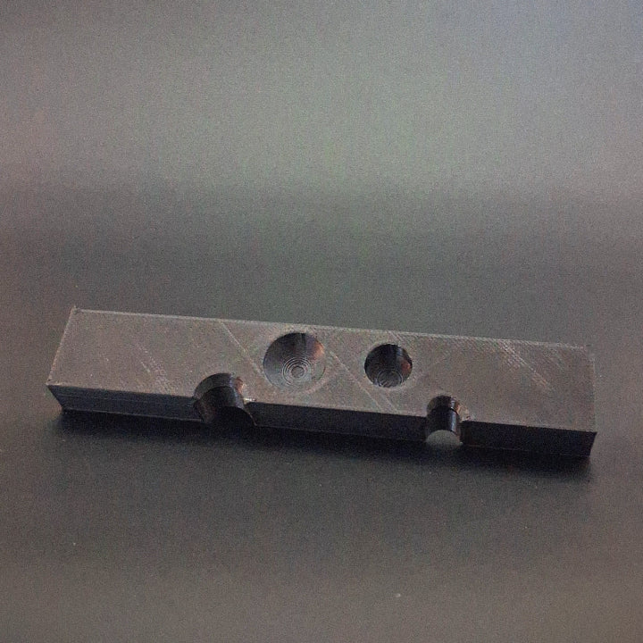 A tool for removing PDR soft tips. Tilted at an angle so that you can see the cut away holes