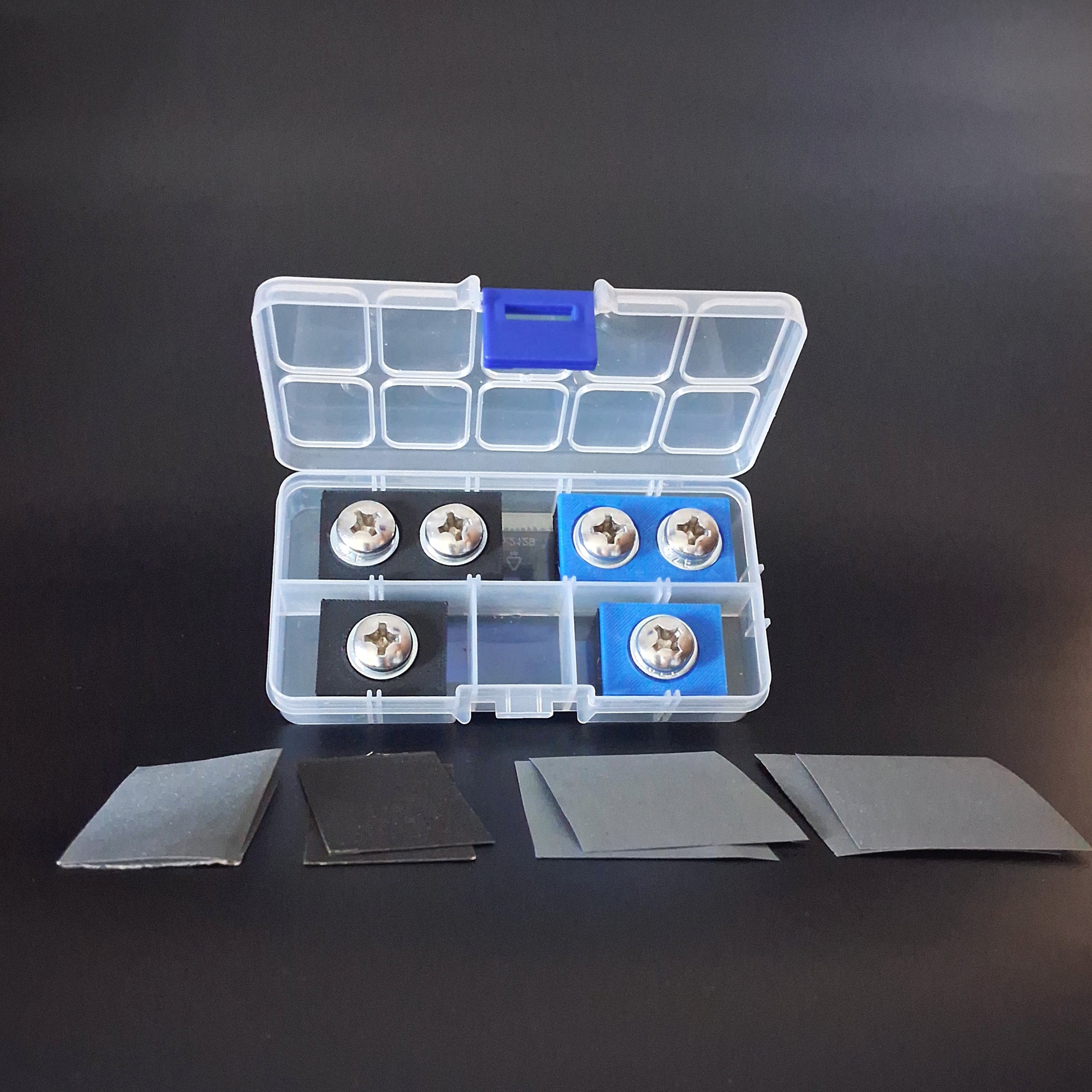 Sanding blocks used for paint correction displayed in a carrying case with extra pieces of sandpaper in front.
