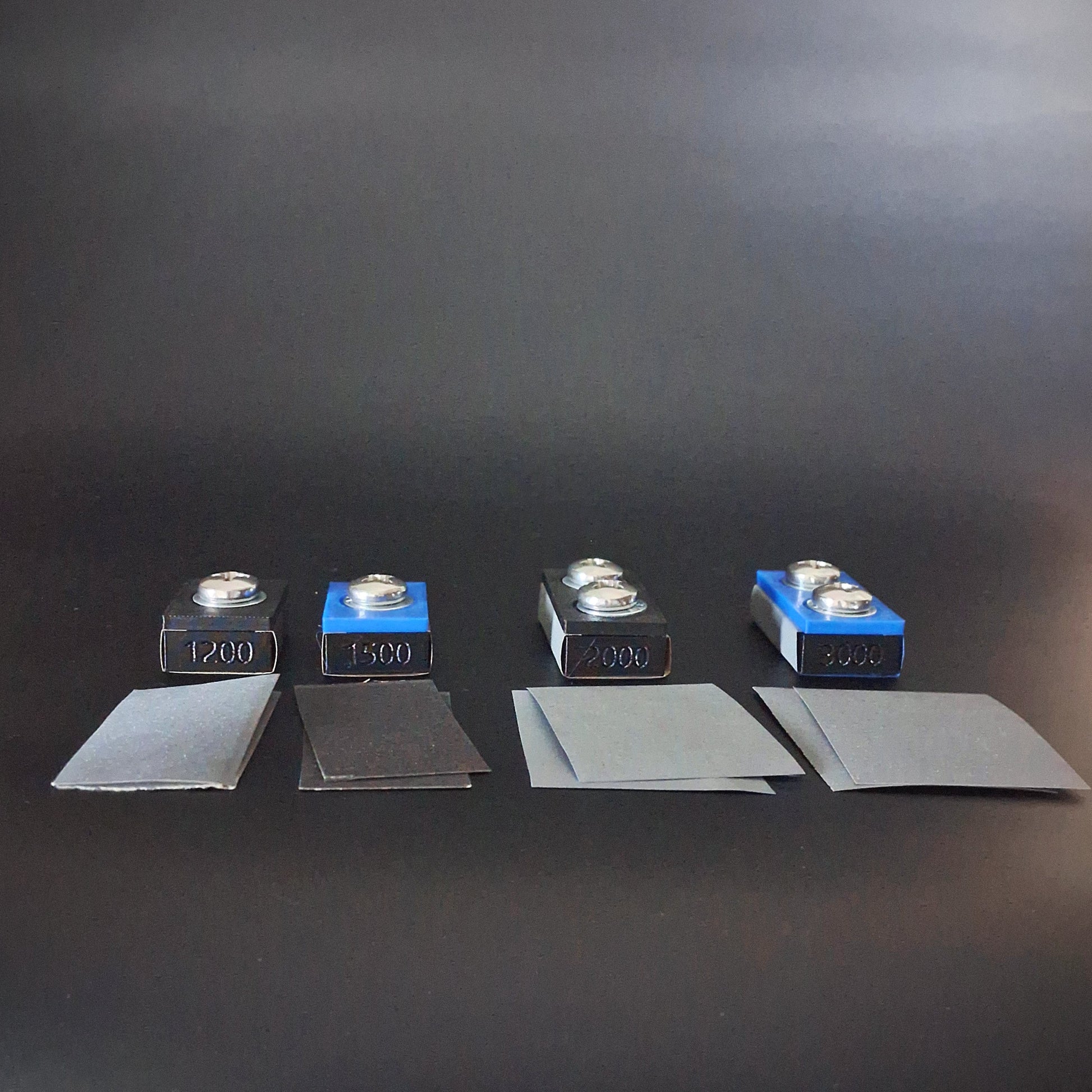4 sanding blocks and extra pieces of sandpaper used in paint correction for an auto detailing business