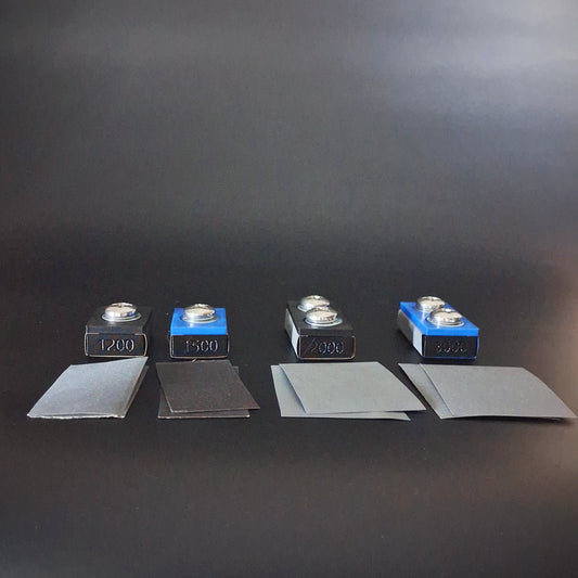 4 sanding blocks and extra pieces of sandpaper used in paint correction for an auto detailing business